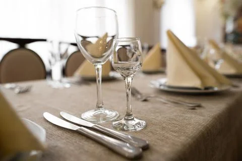Empty goblets and other cutlery are served on the festive table. Stock Photos