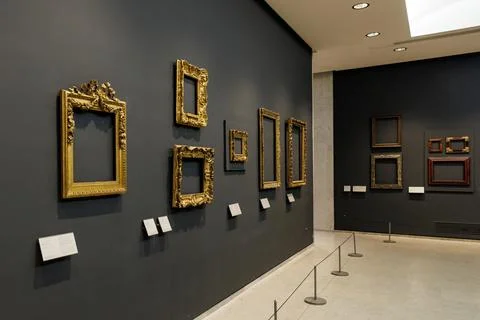Empty gold picture frames on the gallery wall. Stock Photos