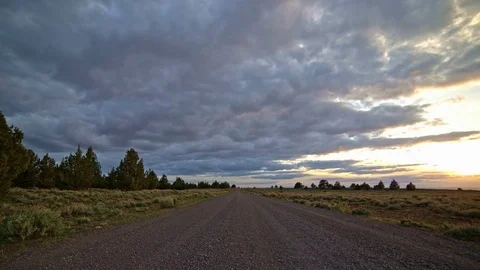 Empty gravel road at sunset with clouds in the desert South Steens Mountain near Video stock 81663004