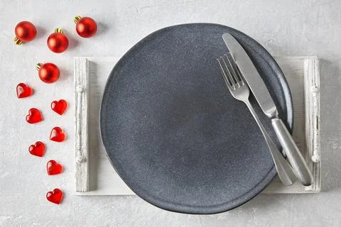 An empty gray ceramic plate with cutlery on a white tray surroun Stock Photos