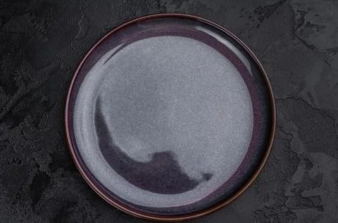 Empty gray ceramic plate top view on background. Glossy round tableware moc.. Stock Photos