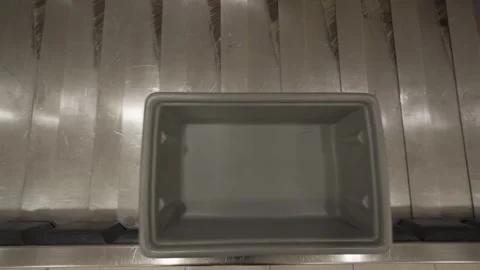 Empty gray plastic bin moving on airport baggage claim conveyor belt 库存影片 310190919