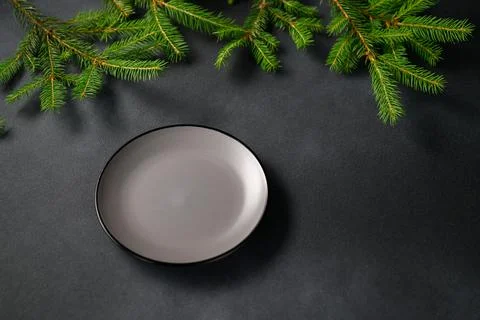 An empty Gray Plate on the Christmas Table with fir branches in the top corne Stock Photos