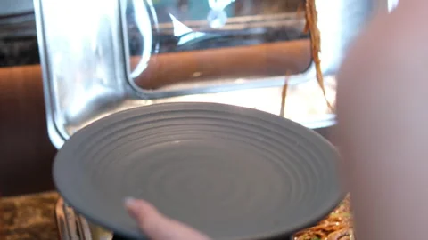 Empty gray plate girl scooping spaghetti onto plate at buffet Stock Footage 316315544