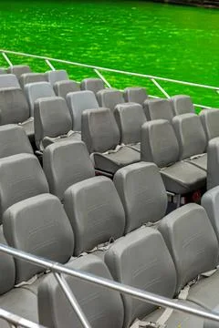 Empty gray stadium seats with green grass background Stock Photos