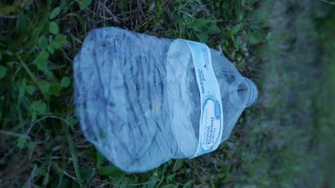 Empty Great Value plastic bottle left as waste on a grassy field Foto stock