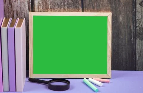 An Empty Green Chalkboard Surrounded by Various Stationery Supplies for an .. Stock Photos