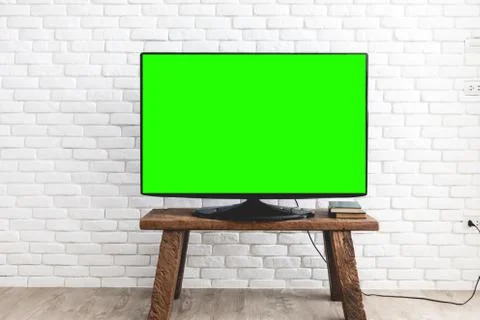 Empty green flat TV screen on wood stand. Stock Photos