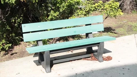 Empty green gray solo single wood wooden bench park outside on pavement cement Vídeo Stock 251365390