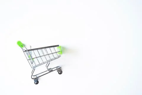 Empty green miniature shopping cart isolated on white background. Stock Photos