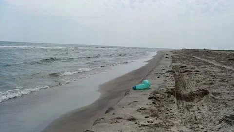 An empty green plastic bottle discarded on a beach. Coastal pollution. Stock Footage 138595151