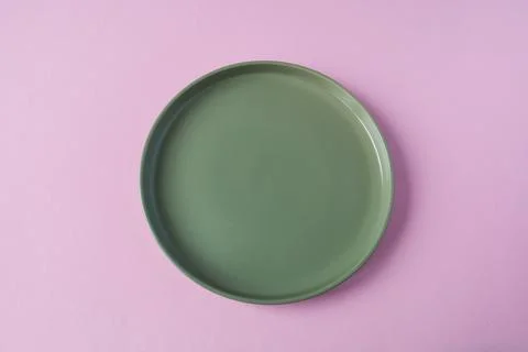 Empty green plate on pink background, top view, copy space. Stock Photos