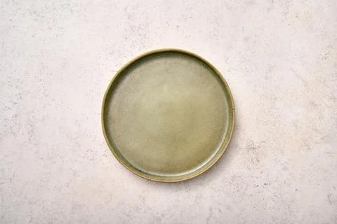 Empty green rustic ceramic plate on light textured marble background Stock Photos