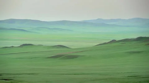 Empty green steppe and rolling hills extend across a broad Mongolian valley Stock Footage 339827895