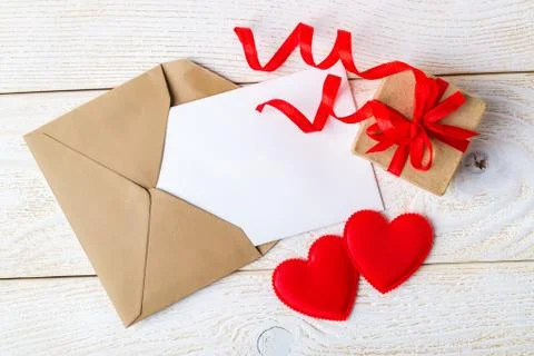 Empty greeting card, gift box with ribbon bow and two valentine hearts Stock Photos