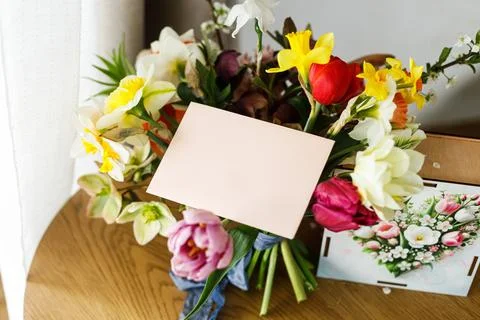 Empty greeting card, gift box and bouquet on wooden table. Happy Mother's d.. Stock Photos
