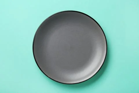 Empty grey ceramic plate on turquoise background, top view Foto stock