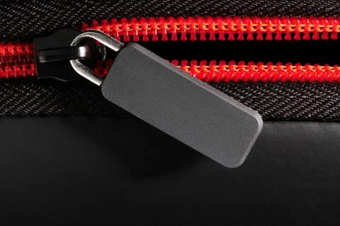 Empty grey label and red zipper fastener on black, close-up, macro, empty spa Illustrazione stock