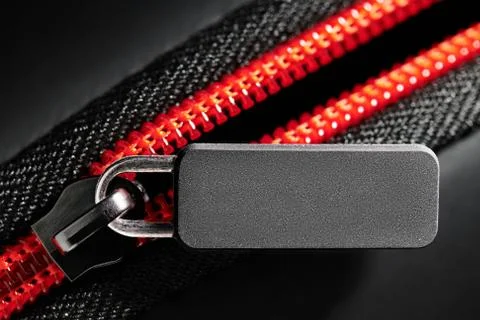 Empty grey label and red zipper fastener on black, close-up, macro, empty spa Stock Photos