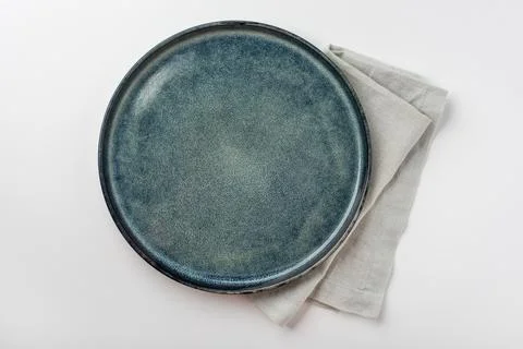An empty grey textured plate on a white table Stock Photos