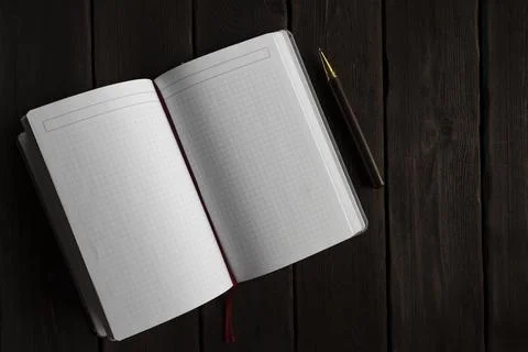 Empty Grid Notebook and Pen on Wooden Desk Stock Photos