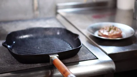 Empty grill frying pan with steam coming up and delicious fried piece of beef Stock Footage 105896154