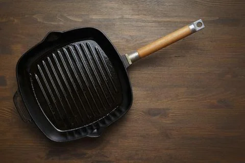 Empty grill pan for frying bbq on wooden table Photos