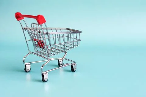 Empty grocery basket on a blue background close-up. Stock Photos