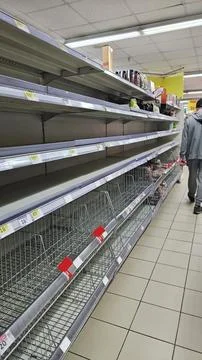 Empty grocery store shelves highlight a significant product shortage. Stock Photos
