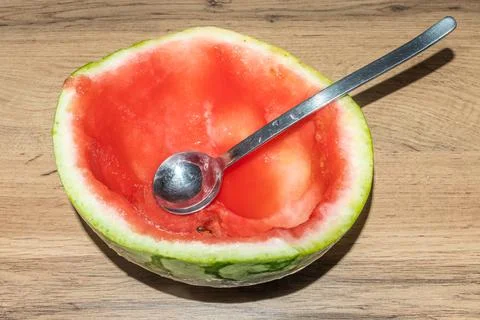 Empty half of watermelon after eating with a spoon close-up Stock Photos