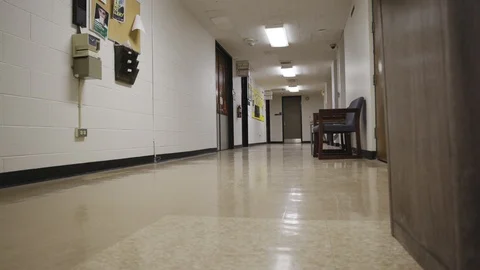 Empty hallway slide past a trash can towards studio room doors Stock Footage 89501125
