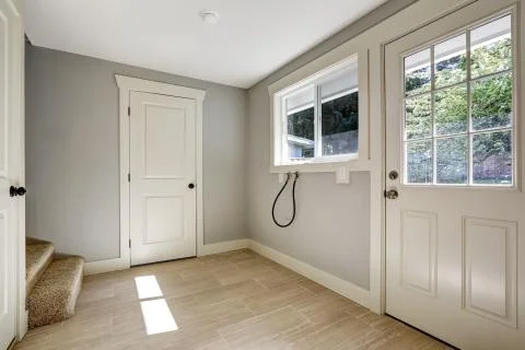 Empty hallway with tile floor and entrance door Stock Photos