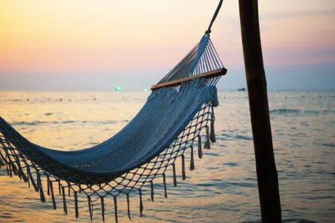 Empty hammock between palm trees on tropical beach Stock Photos