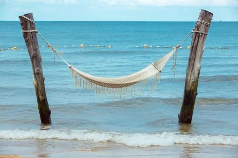 Empty hammock between palm trees on tropical beach Stock Photos