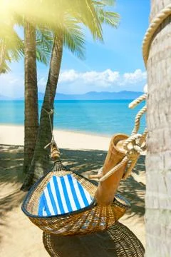 Empty hammock between palms trees at sandy beach Stock Photos