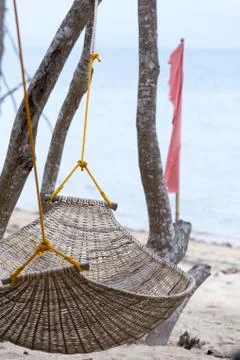 Empty hammock on a palm tree by the sea, vacation concept. Stock Photos