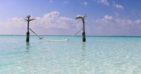An empty hammock swinging over tropical, turquoise sea Stock-Footage 124415127