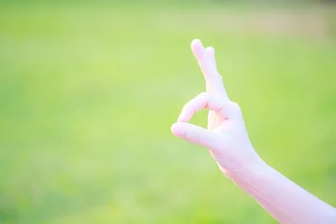 Empty hand in ok gesture closeup light green background with copy space Stock Photos
