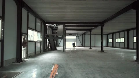 An empty hangar under construction where the builders are going Stock Footage 134490782