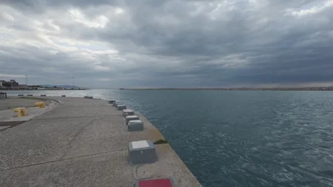 Empty Harbor Pier With Curved Dock Benches Under Cloudy Sky Vídeo Stock 338108636