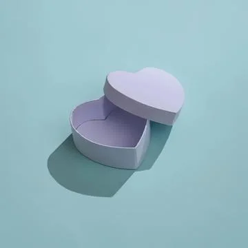 Empty heart-shaped gift box with lid open on blue background Stock Photos