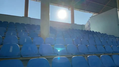 Empty high school stadium plastic chairs in row on sunny day Stock Footage 139325791