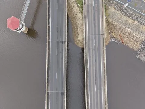 Empty highway bridge spanning across a dam reservoir Stock Photos