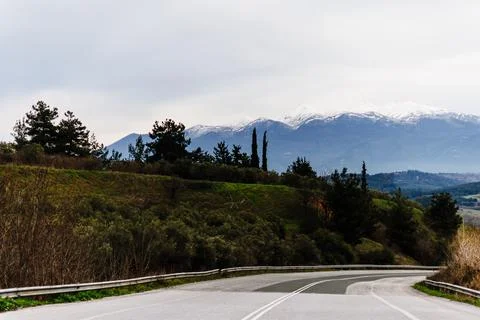 Empty Highway with Forest and Distant Mountains Stock Photos