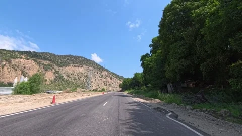 Empty highway with fresh pavement stretches into hilly landscape Stock Footage 340081175