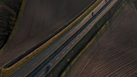 Empty highway running through agricultural land in early morning light seen from Stock Footage 325825375