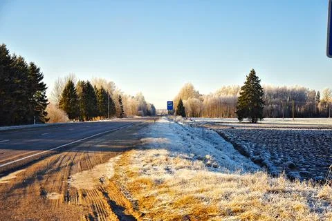 Empty highway with snow fields on both sides with a beautiful day Stock Photos