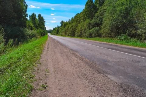 Empty highway through green forest Stock Photos