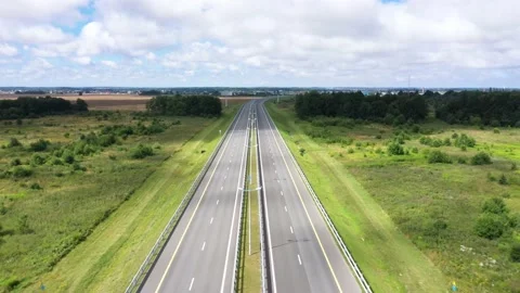 Empty highway with two lanes and streetlights across meadow Video stock 149611174