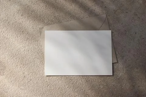 Empty horizontal greeting card invitation mockup, craft envelope. Beige Stock Photos